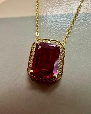 10k yellow gold created ruby and diamond pendant.

1 ruby 6x8mm
28 diamonds 0.08ct total weight.